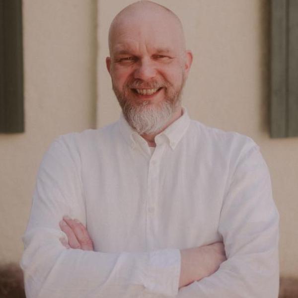 Iloinen mies kokinvaatteissa.